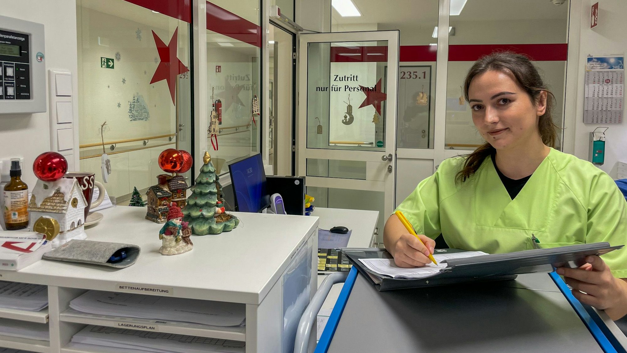 Florentina Gashi steht mit einer Mappe in der Hand im Stationszimmer.