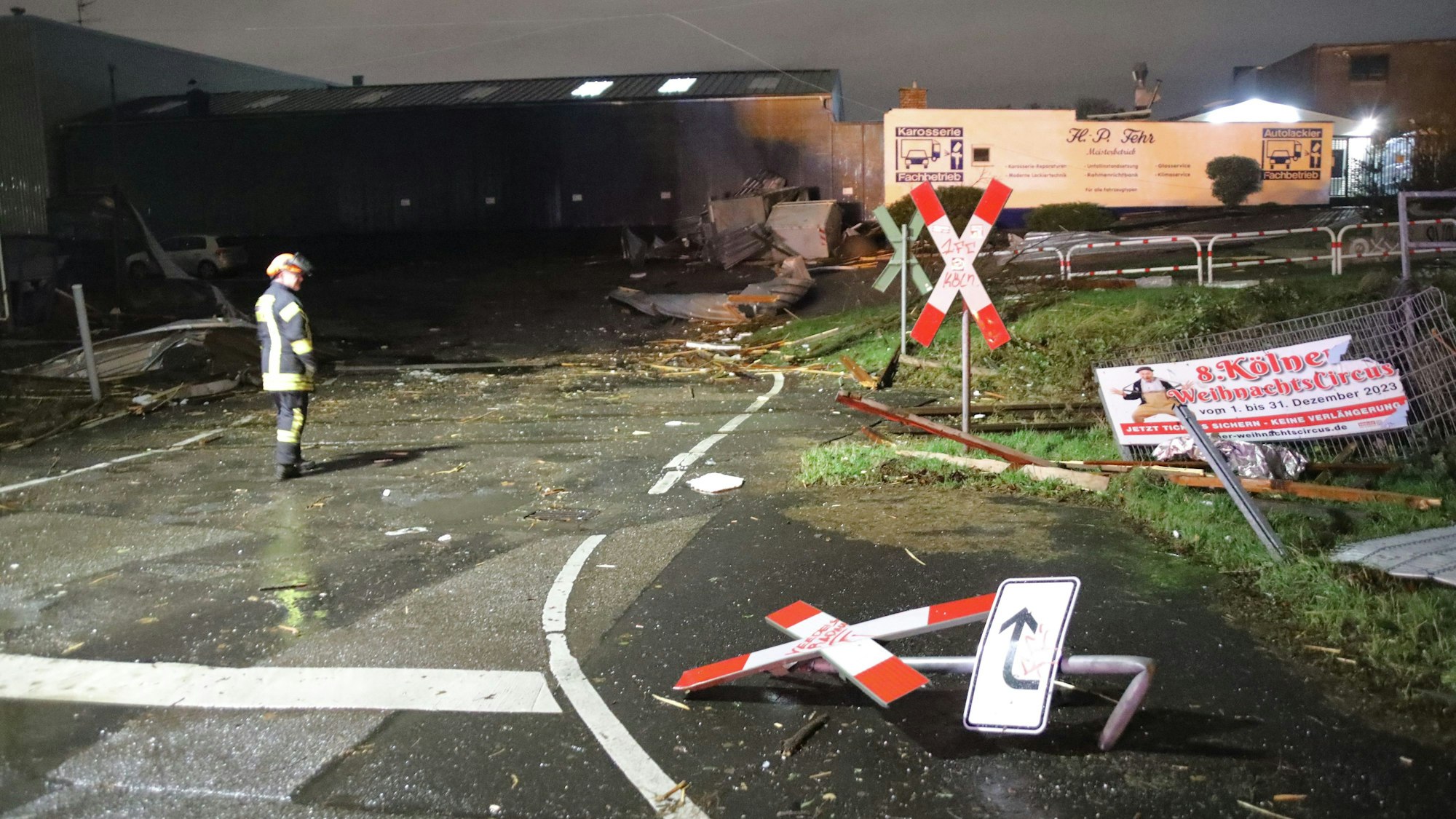 Ein Feuerwehrmann betrachtet die Trümmer und Schäden an einem Bahnübergang.