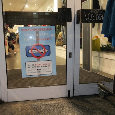 Auf einem Plakat steht „Verkehrsversuch Venloer Straße sofort stoppen“.