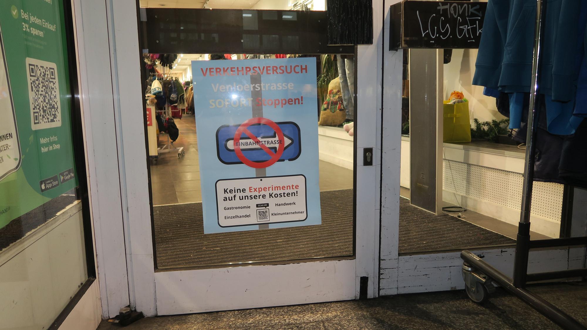 Auf einem Plakat steht „Verkehrsversuch Venloer Straße sofort stoppen“.