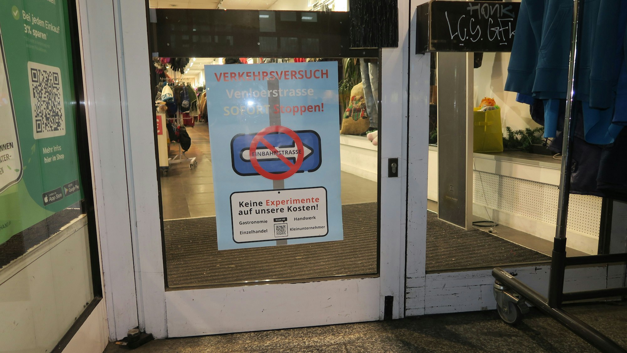Auf einem Plakat steht „Verkehrsversuch Venloer Straße sofort stoppen“.