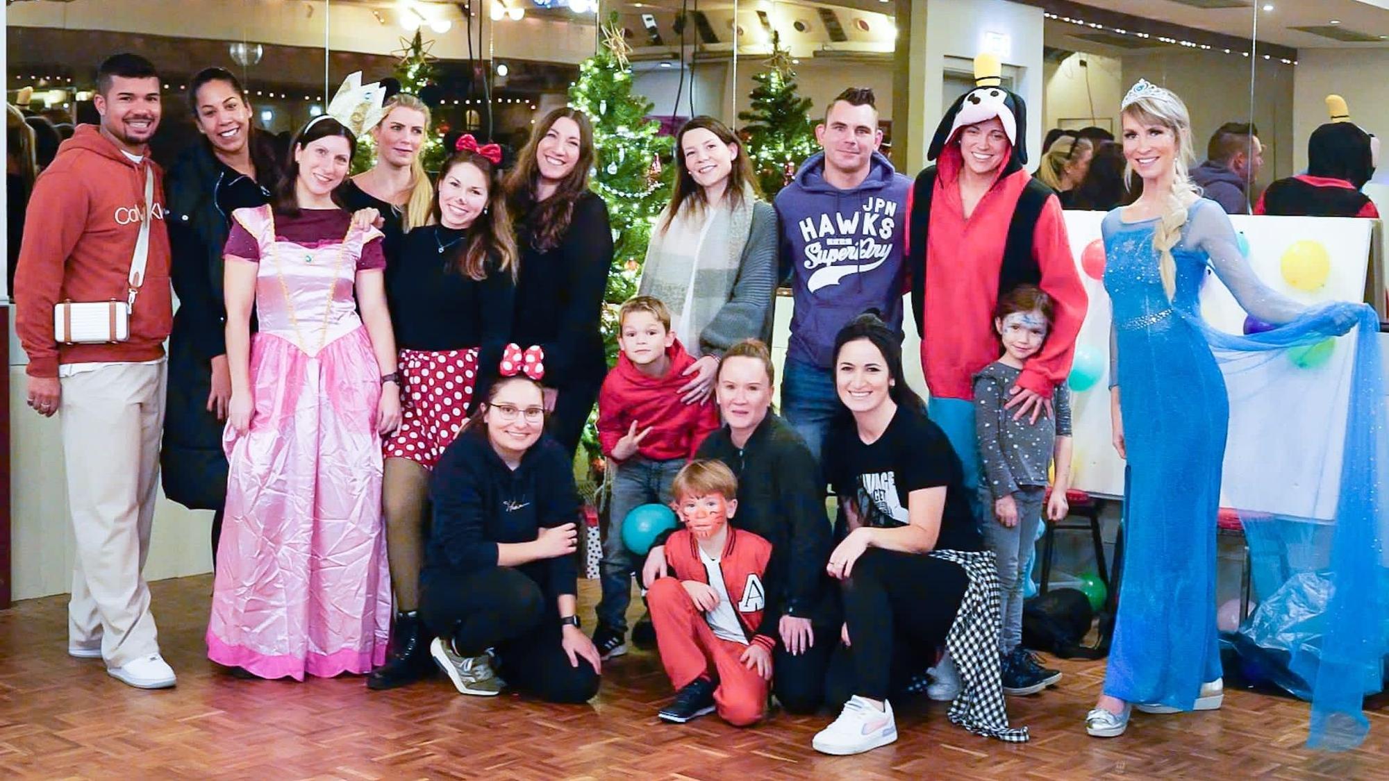 Frauen, Männer und Kinder, teils in Kostümen, posieren für ein Gruppenfoto.