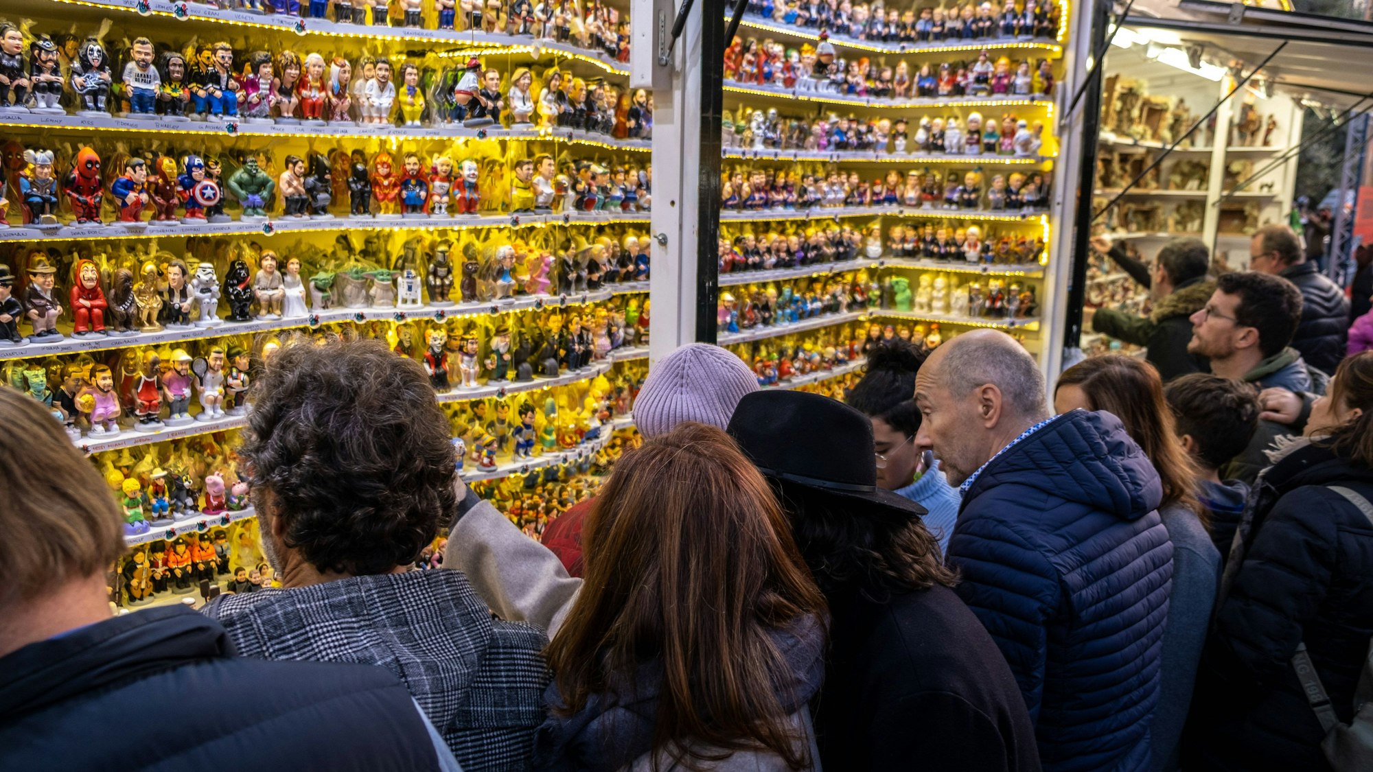 Eine Gruppe an Menschen steht vor einem Laden, welcher die berühmte Caganer-Figur verkauft.