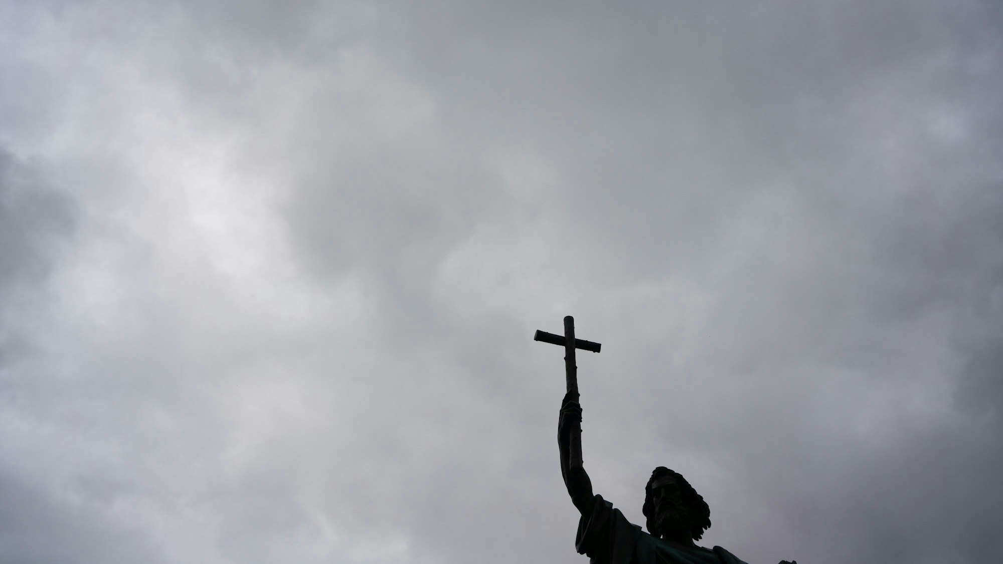 Die Statue des heiligen Bonifatius steht vor einem regenschweren Himmel.