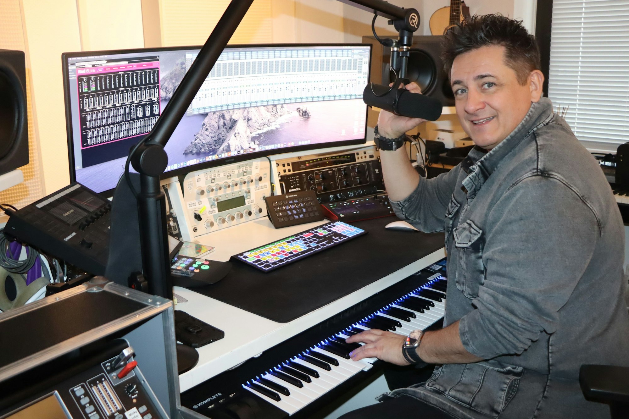 Ein Man sitzt am Keyboard vor einem Bildschirm.