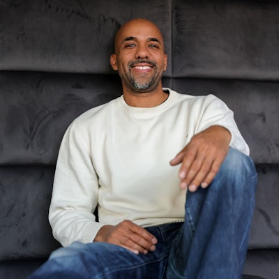 Clifford Opoku-Afari sitzt vor einer Wand in seinem Studio.