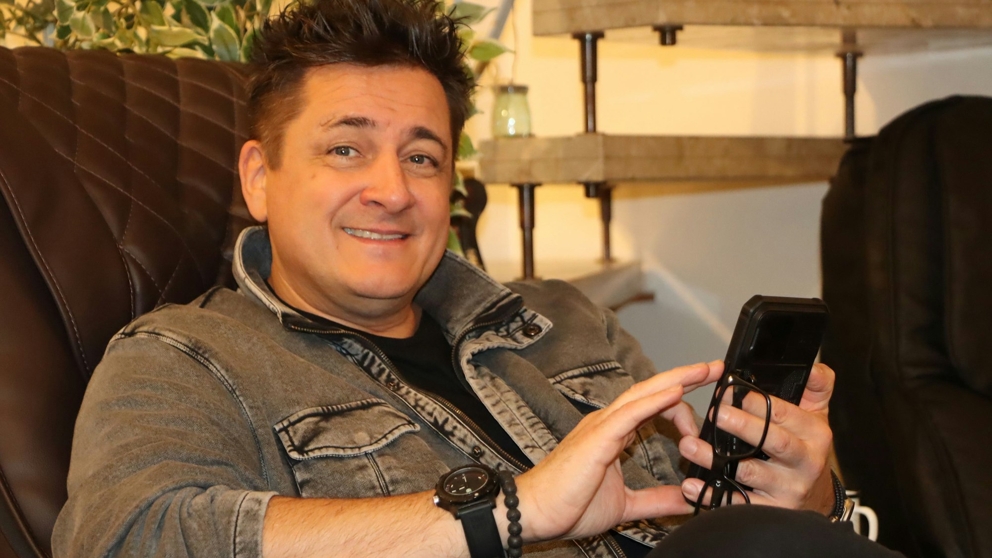 Ein Mann schreibt etwas in sein Handy.