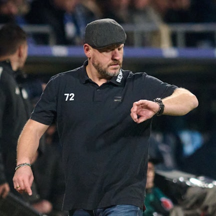 Während der Bundesliga-Begegnung VfL Bochum gegen 1. FC Köln am 11. November 2023 schaut Kölns Trainer Steffen Baumgart am Spielfeldrand auf seine Armbanduhr. Er trägt Schirmmütze und ein schwarzes T-Shirt.