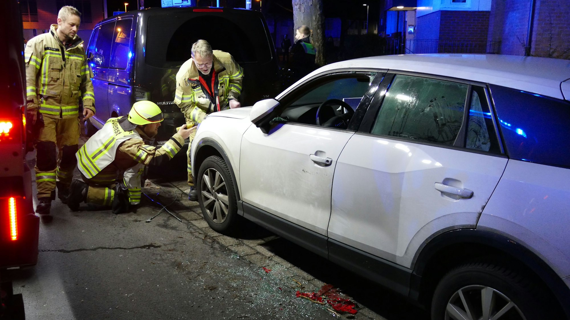 Rettungskräfte stehen am einem weißen Auto.