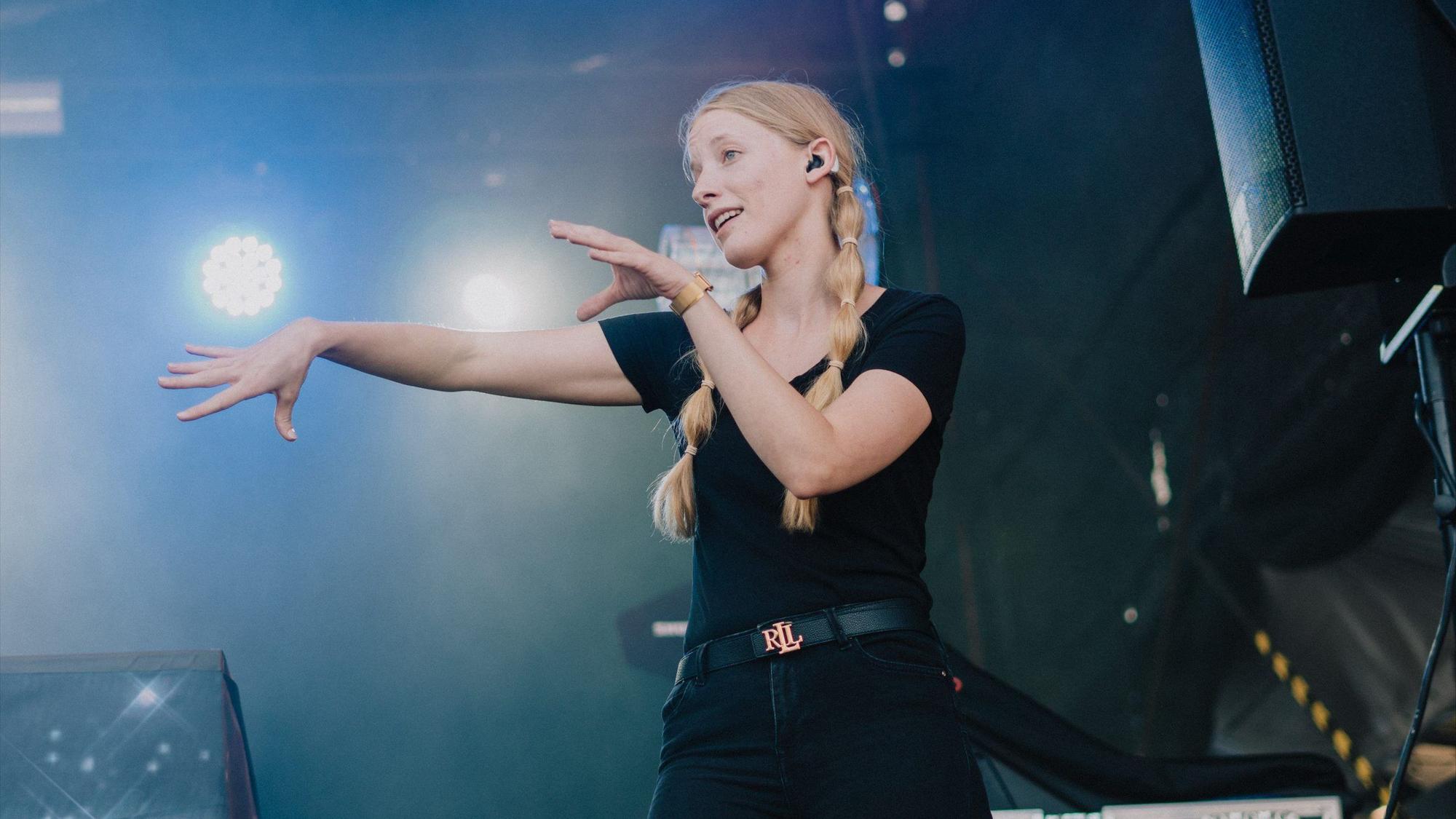 HANDOUT - 22.07.2023, München: Die Deaf Performerin Cindy Klink steht beim Oben Ohne Open Air auf der Bühne.
Cindy Klink steht bei einem Konzert auf der Bühne und zeigt das Lied in Gebärdensprache.