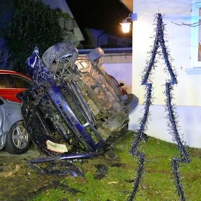 Ein Auto liegt auf dem Dach auf zwei anderen Autos.