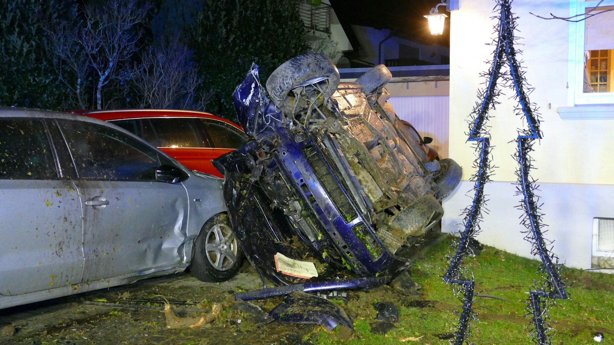 Ein Auto liegt auf dem Dach auf zwei anderen Autos.