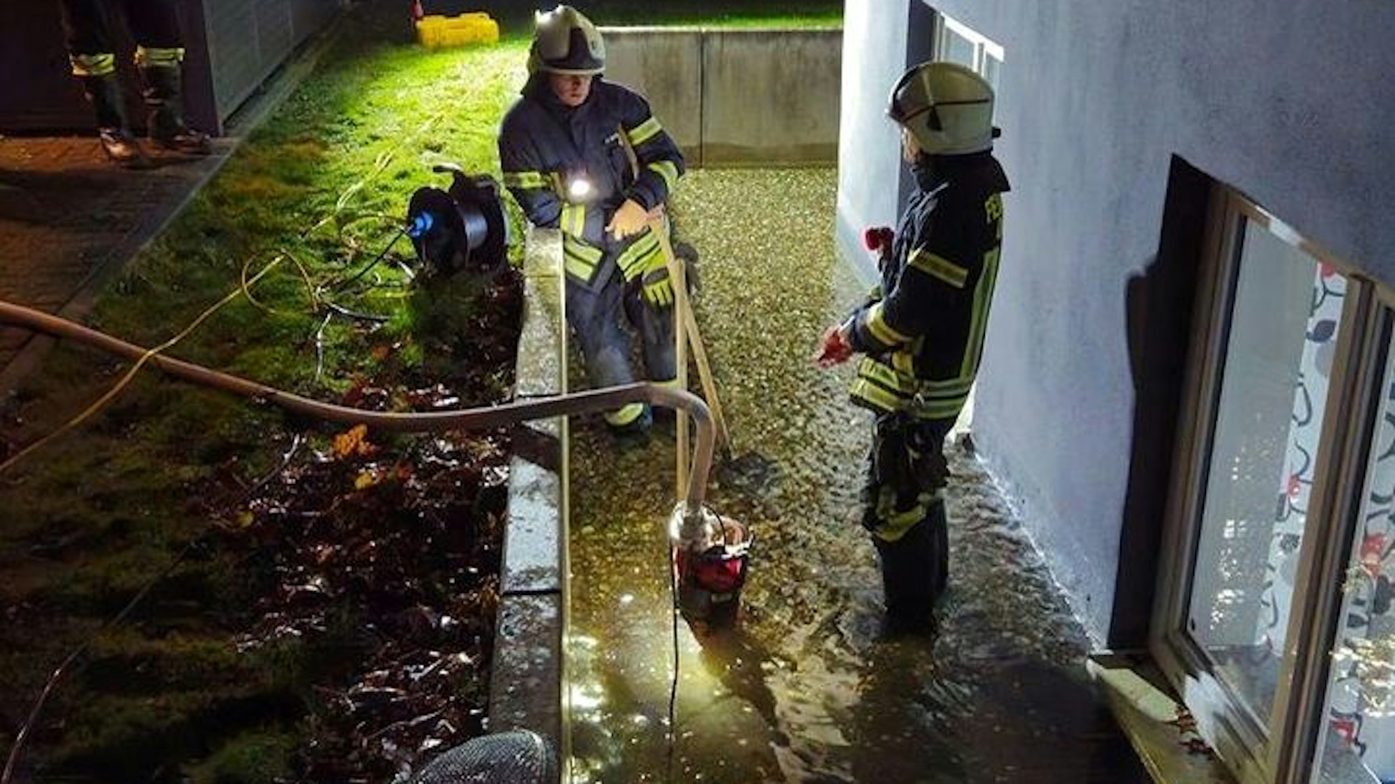 Feuerwehr pumpen mit einer Tauchpumpe an der Fischerstraße Grundwasser ab, das in eine Souterrainwohnung zu laufen droht.