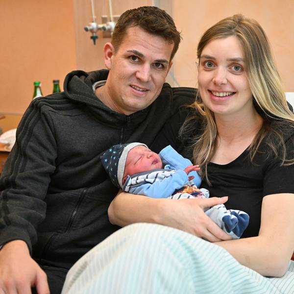 Marie Duske und Helge Hohl sitzen mit ihrem frisch geborenen Sohn in einem Bett im Evangelischen Krankenhaus Bergisch Gladbach.