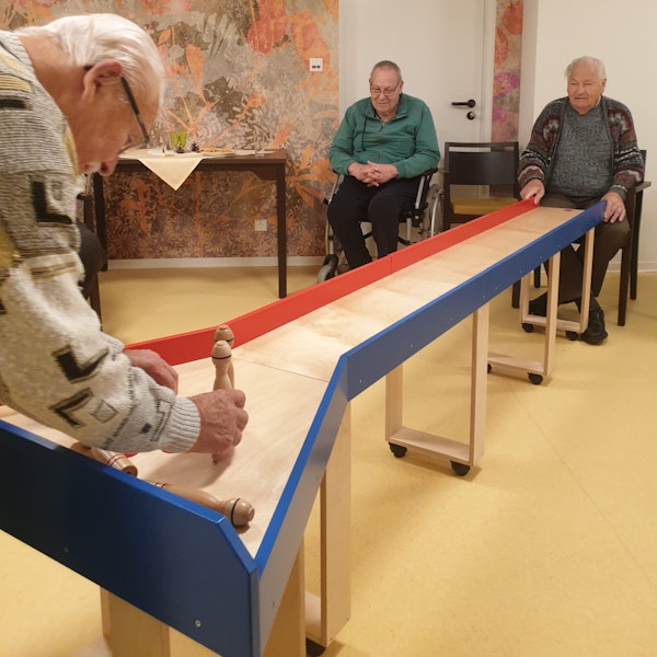 Mehrere Männer kegeln auf einer Tisch-Kegelbahn im DRK-Seniorenzentrum Wipperfürth.