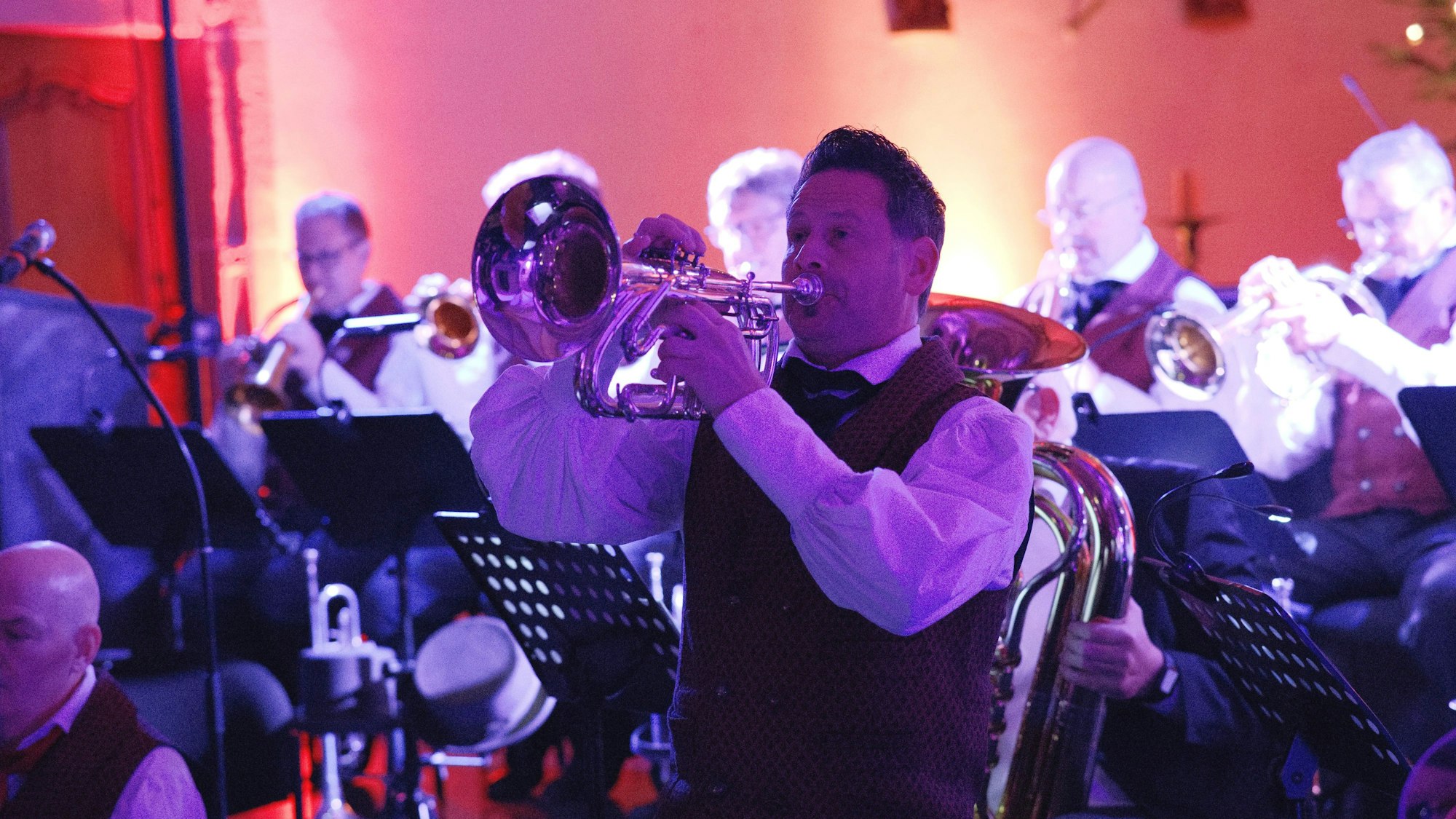 Ein Trompeter spielt in der Schwerfener Kirche. Im Hintergrund sind weitere Musiker zu sehen.