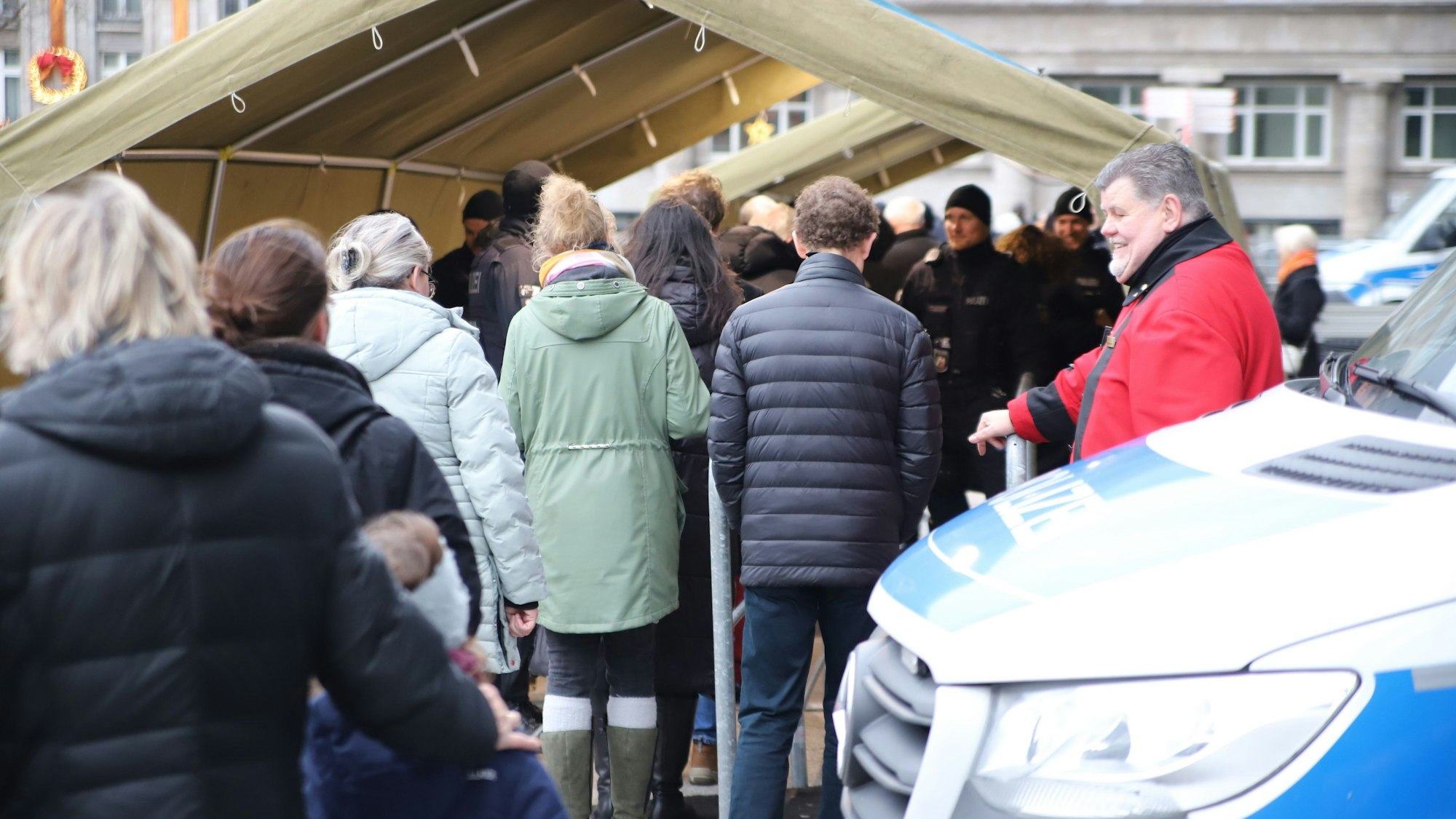 Menschen stehen am Kölner Dom an.