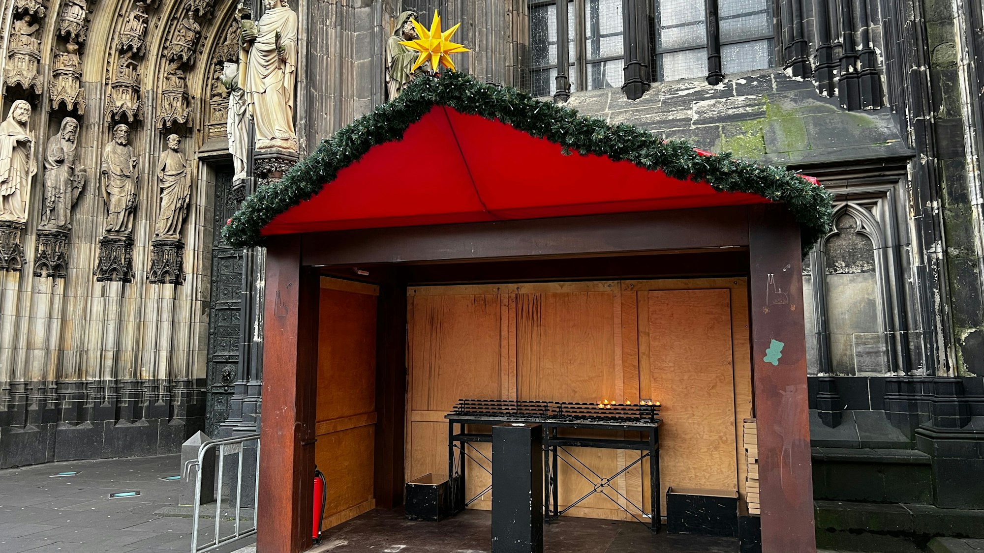 Ein Weihnachtsmarktstand steht vor dem Dom