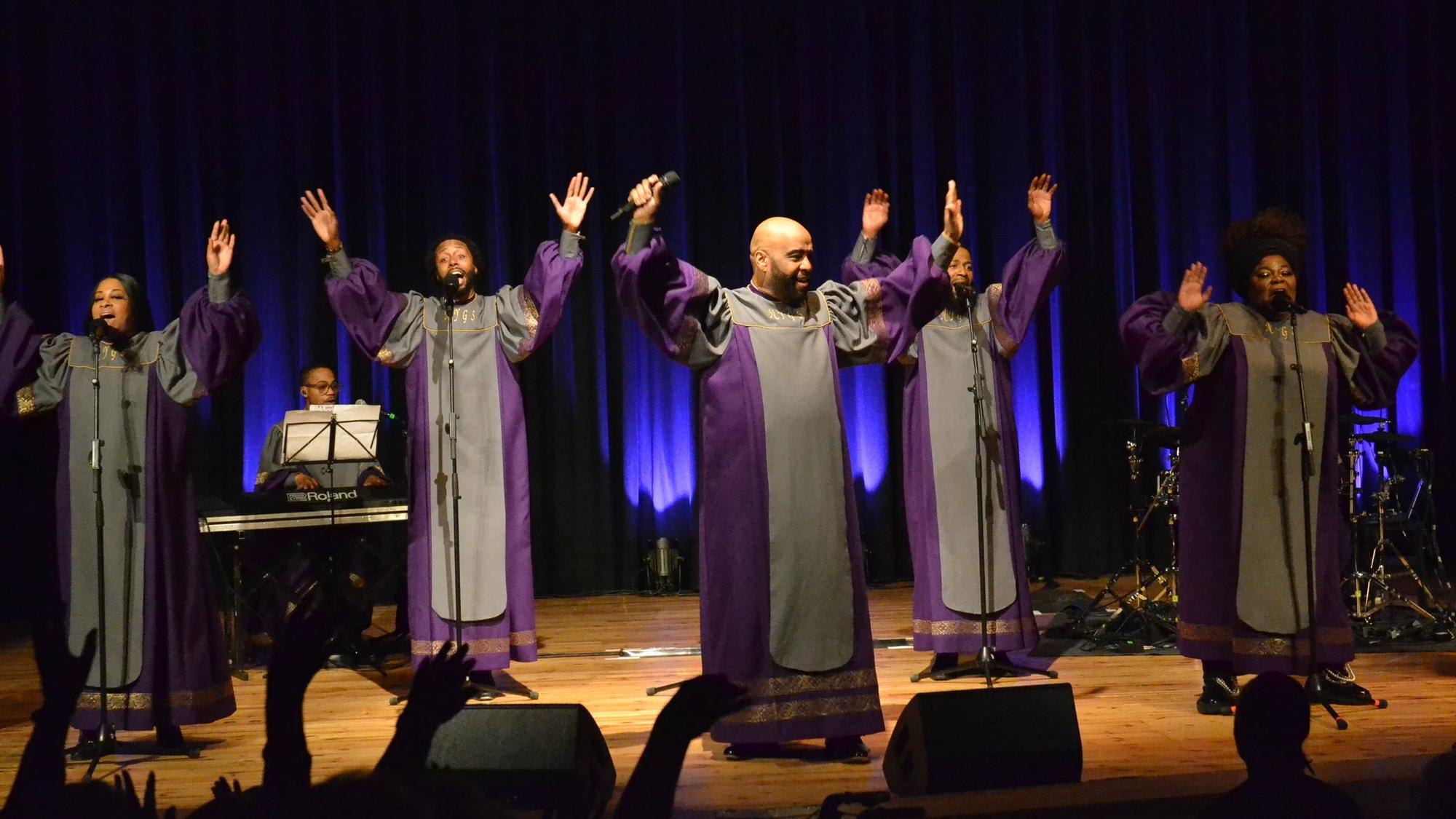 Das Ensemble der New York Gospel Stars steht mit erhobenen Armen auf der Bühne im Euskirchener Stadttheater und singt.