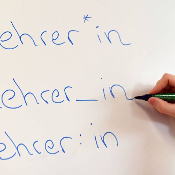 An einem Whiteboard steht das Wort Lehrer in verschiedenen Gender-Schreibweisen.