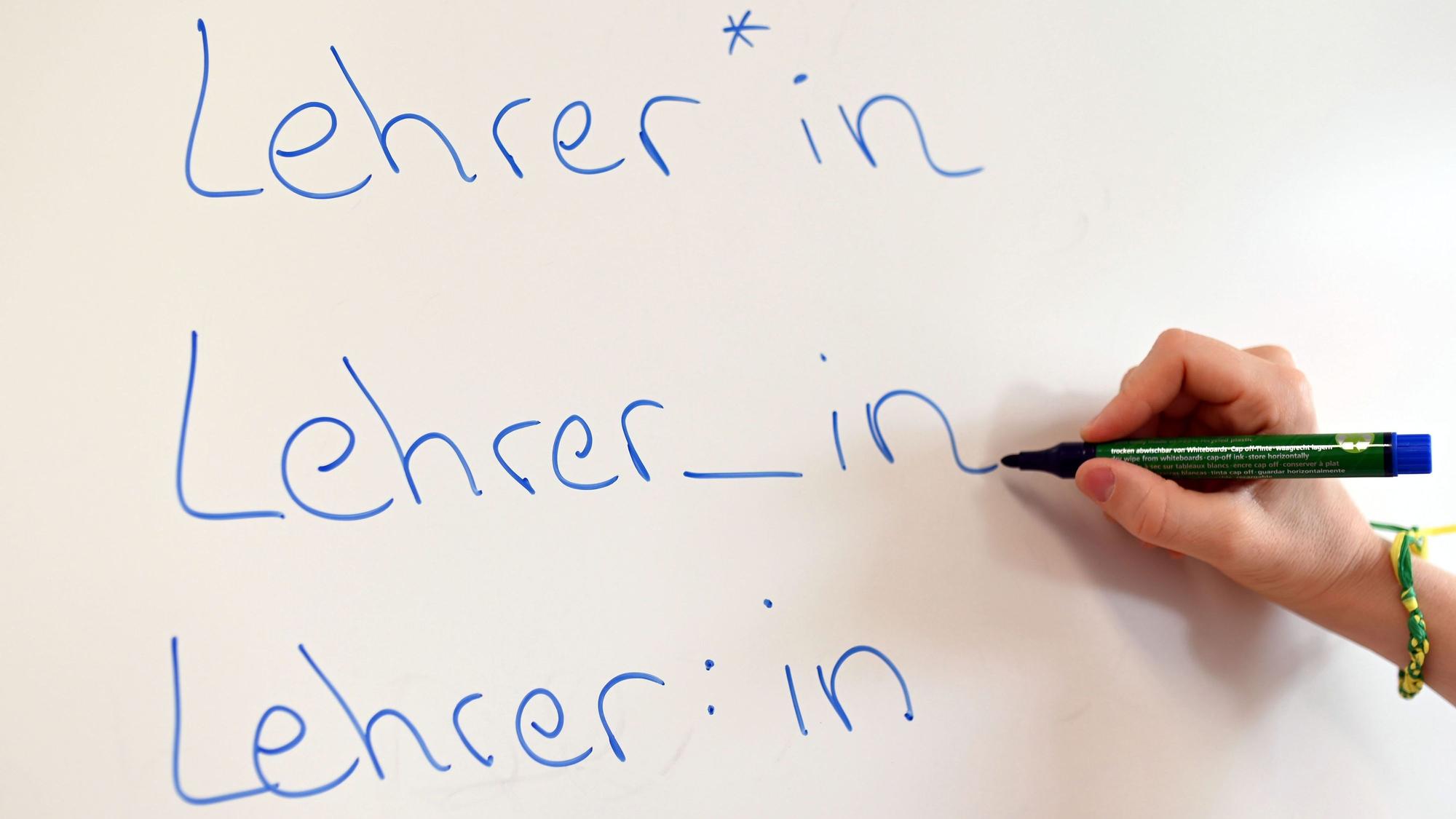 An einem Whiteboard steht das Wort Lehrer in verschiedenen Gender-Schreibweisen.