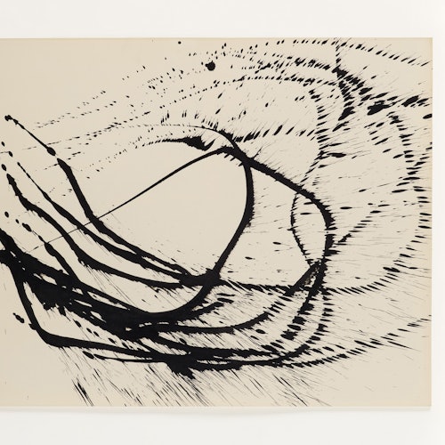 Schwarze Tinte ist in Schwüngen und Spritzern über ein Blatt Papier verteilt.