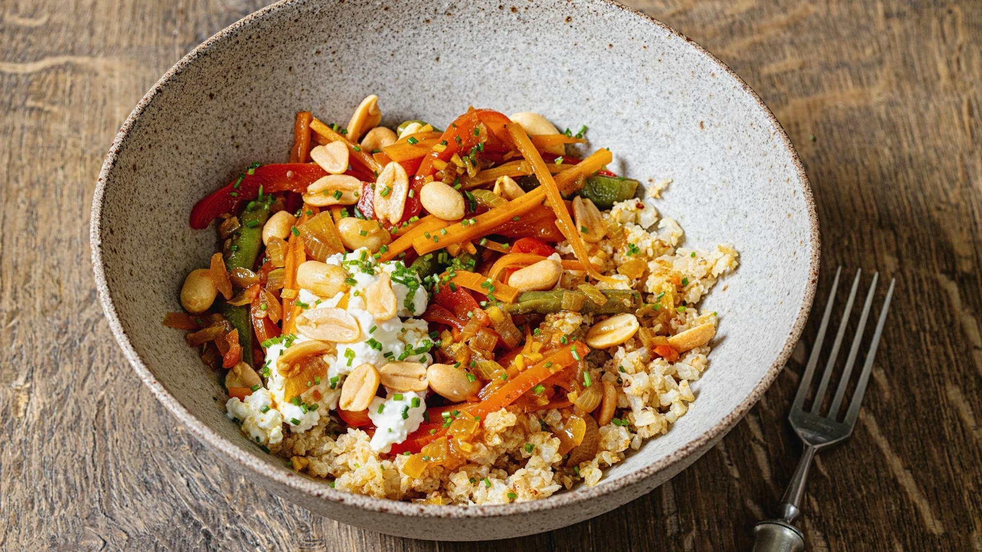 Eine Bowl mit Blumenkohlreis und Gemüse.