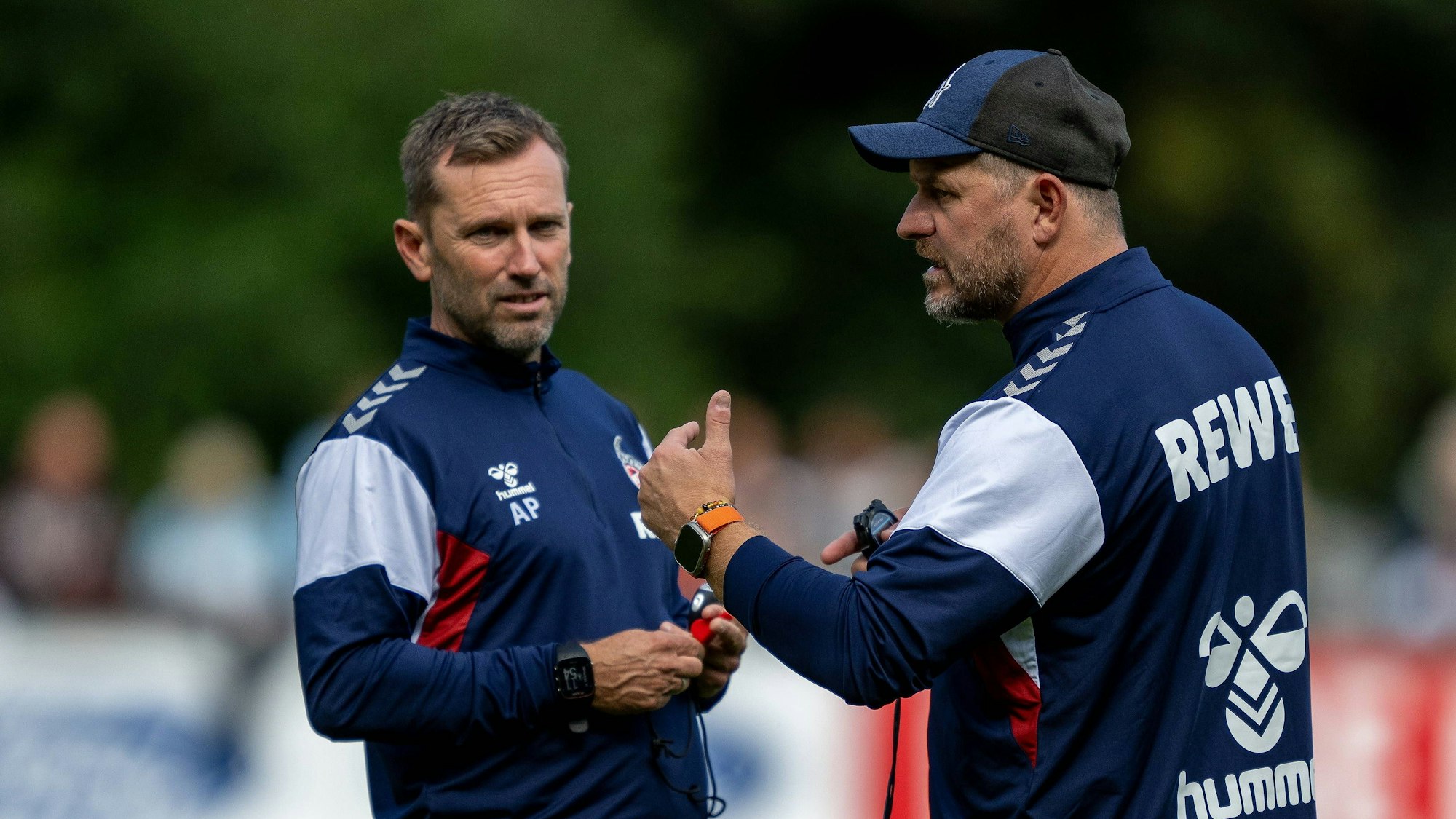 Steffen Baumgart (r.), Trainer des 1. FC Köln, tauscht sich mit seinem Assistenten André Pawlak aus.