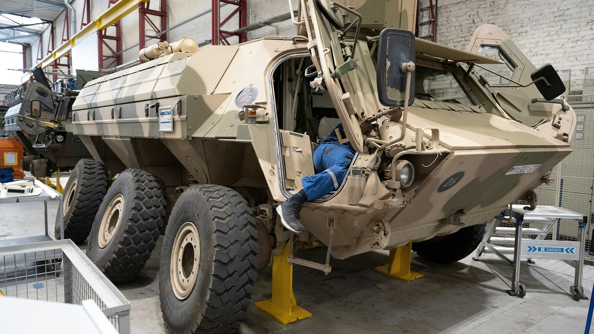 Ein Mitarbeiter von Rheinmetall arbeitet an einem Panzer vom Typ Fuchs in der Fertigungshalle von Rheinmetall in Kassel.