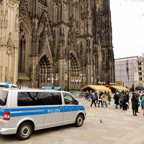 Mannschaftswagen der Polizei parken vor dem Kölner Dom.