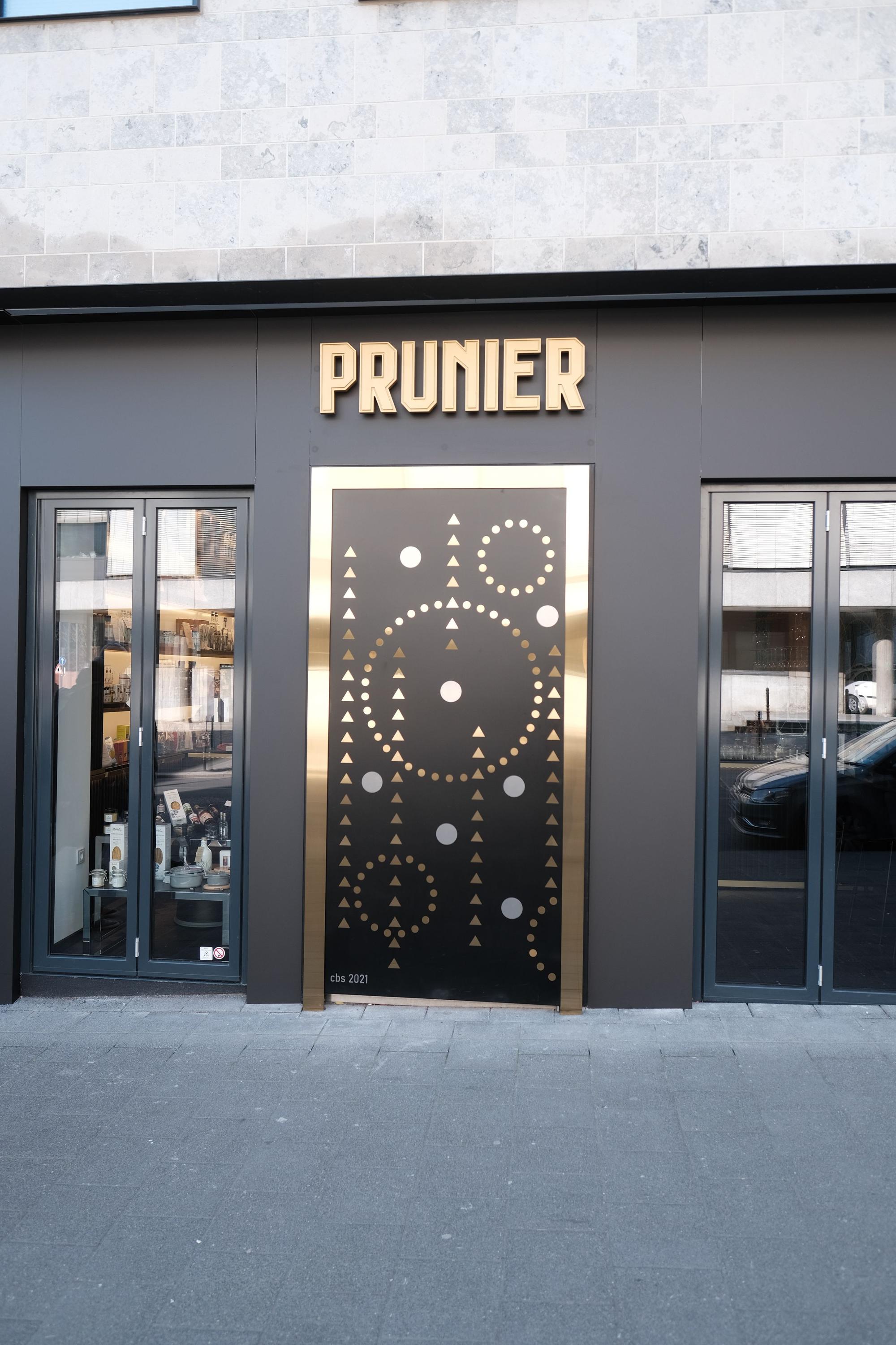 Die Eingangstür zum Restaurant. Über der schwarz-goldenen Tür steht in goldenen Lettern „Prunier“.