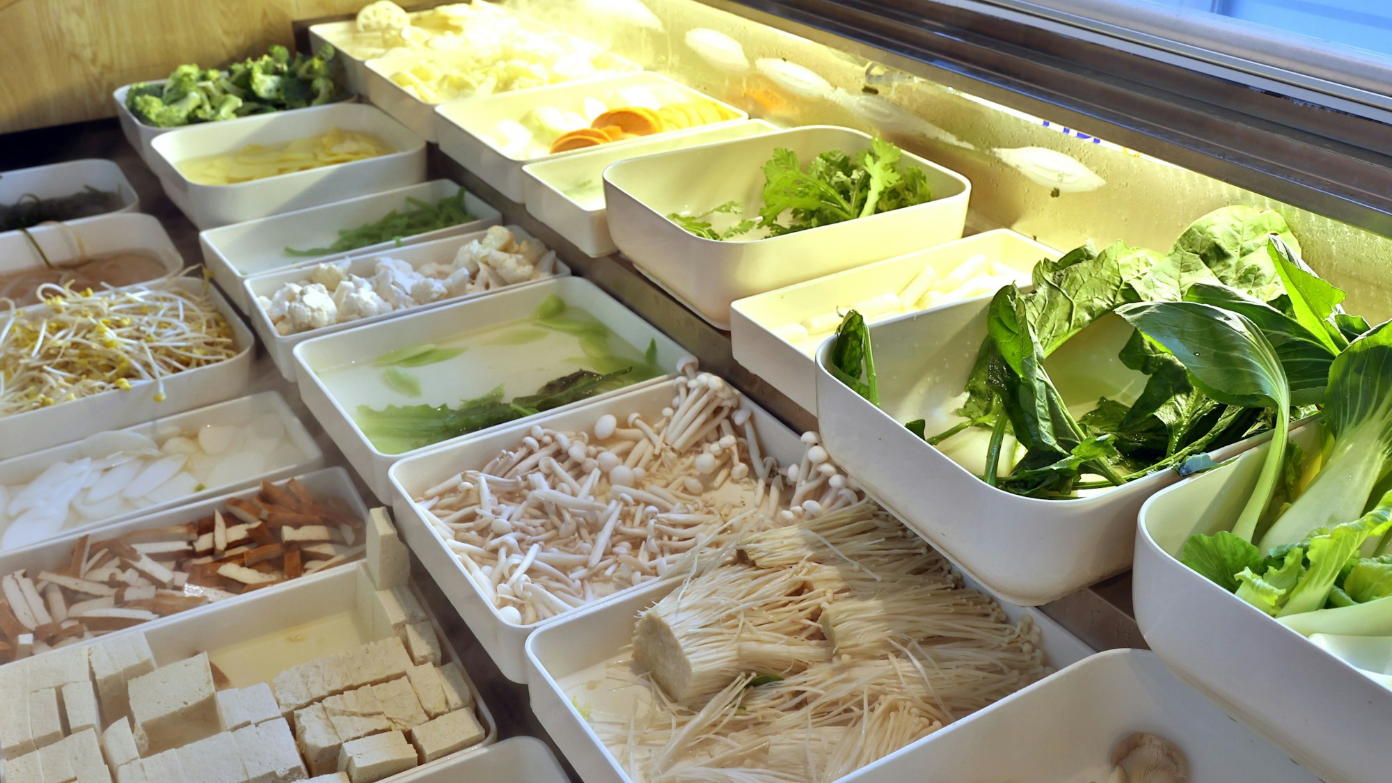 In verschiedenen Schalen liegen Zutaten für eine chinesische Nudelsuppe.