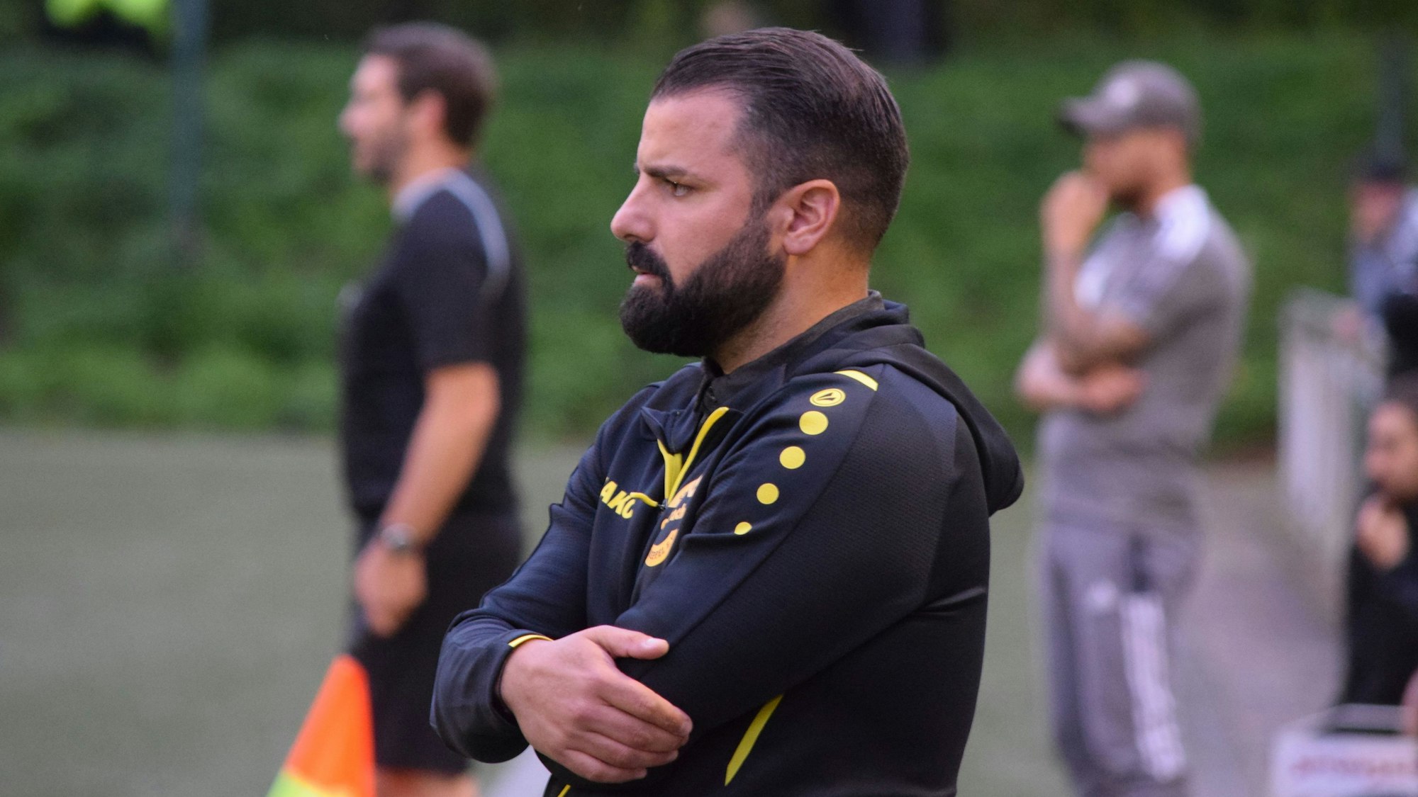 Trainer Mahmut Temür verfolgt mit verschränkten Armen das Geschehen auf dem Spielfeld.