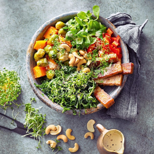 Bunte Bowl mit Ofengemüse, frischen Grünkohlblättern und gebratenem Tempeh. F