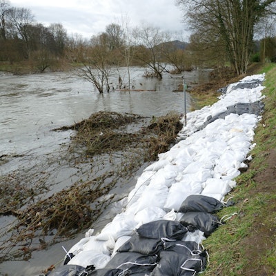 Zahlreiche Sandsäcke sichern einen Deich.