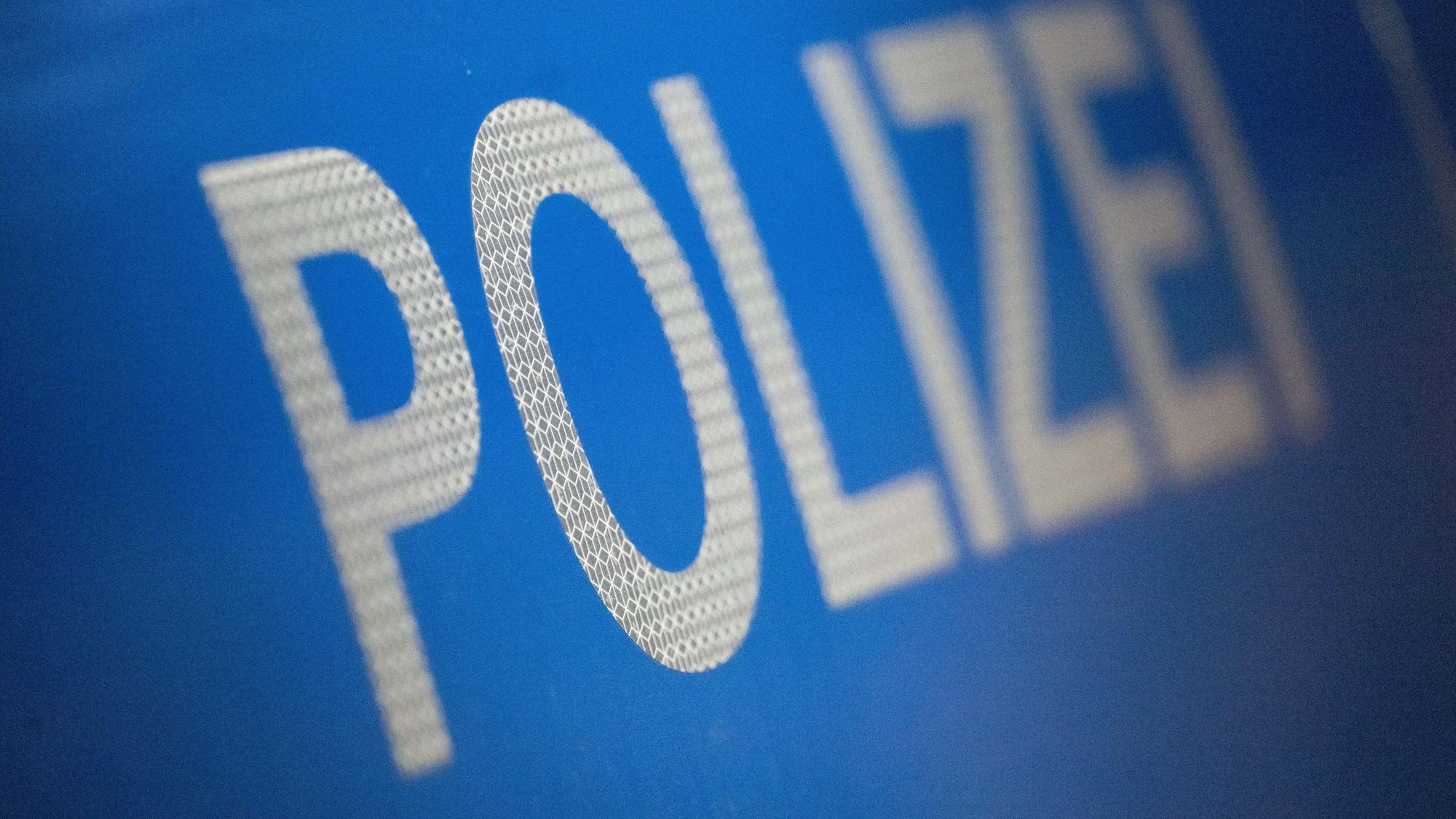Das Wort Polizei ist auf blauem Untergrund zu lesen.