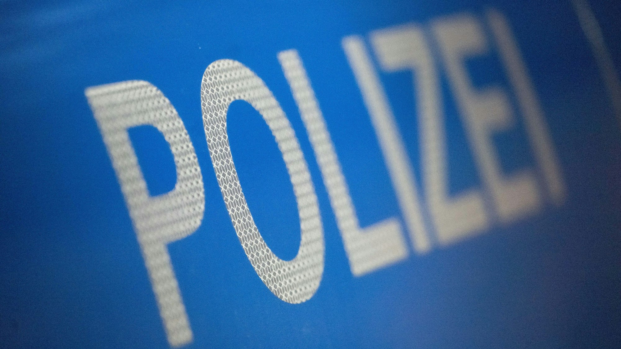 Zu sehen ist die Karosserie eines Polizeifahrzeugs.