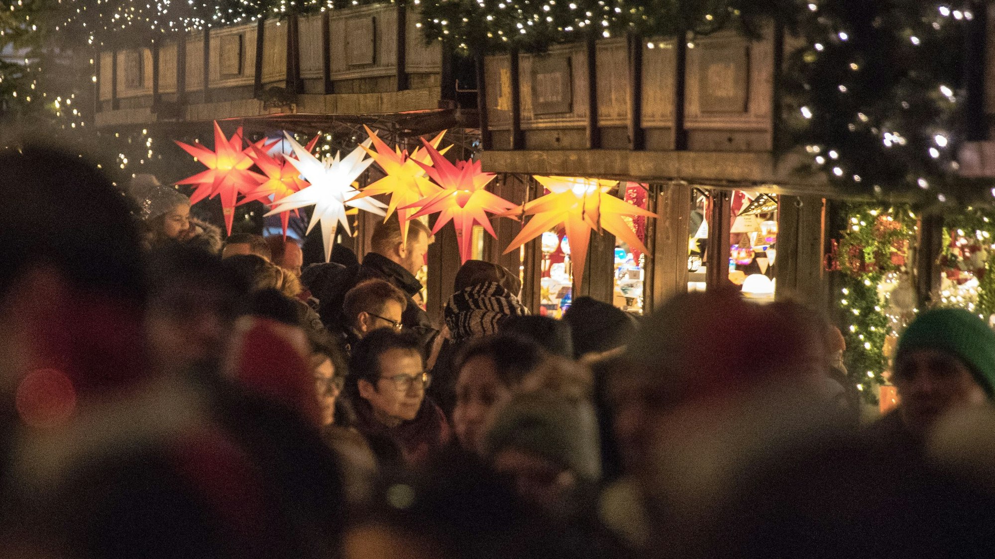 Menschen besuchen den Weihnachtsmarkt am Dom in Köln.