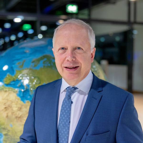 WDR-Intendant Tom Buhrow steht vor einer Weltkugel. Er trägt einen blauen Anzug und lächelt in die Kamera.