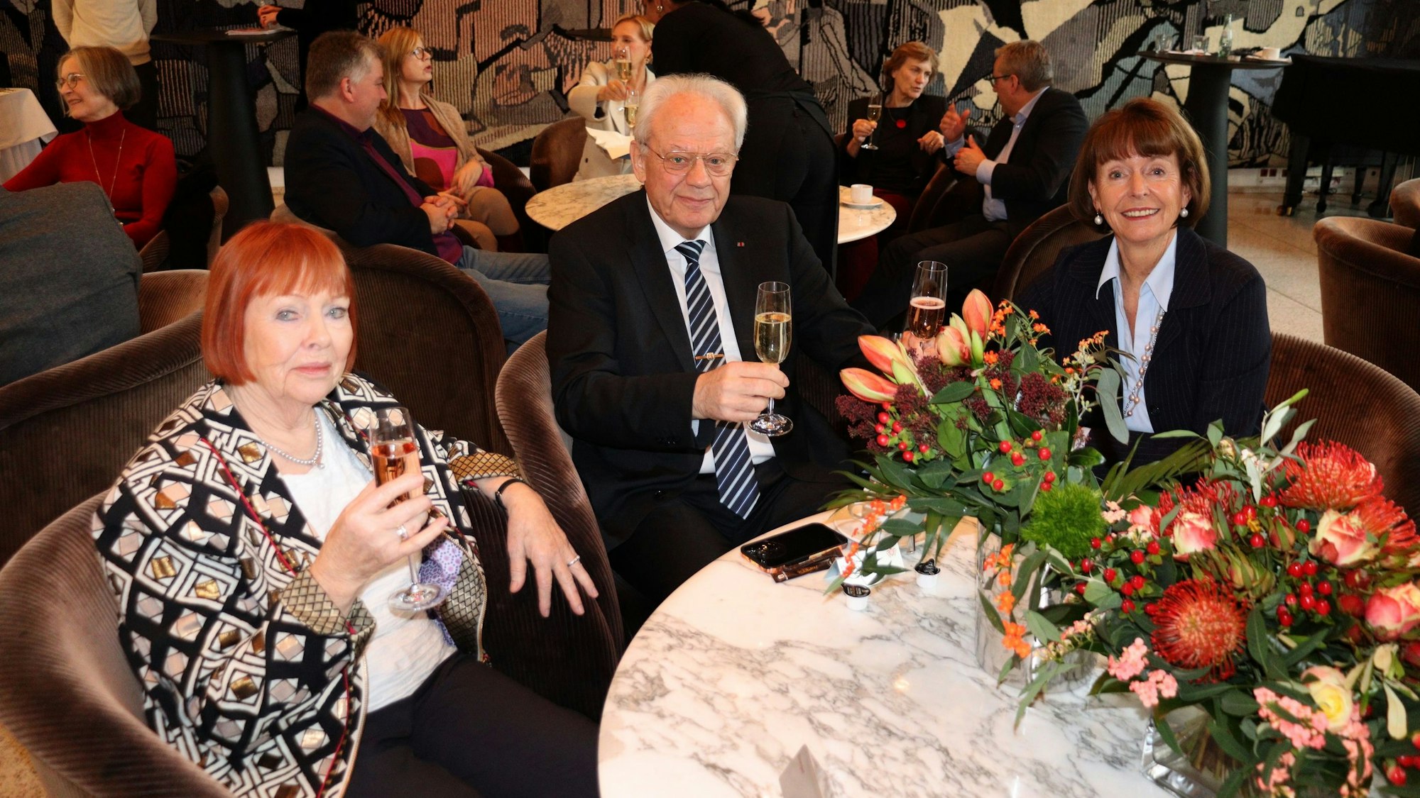 Drei Gäste sitzen an einem Tisch.