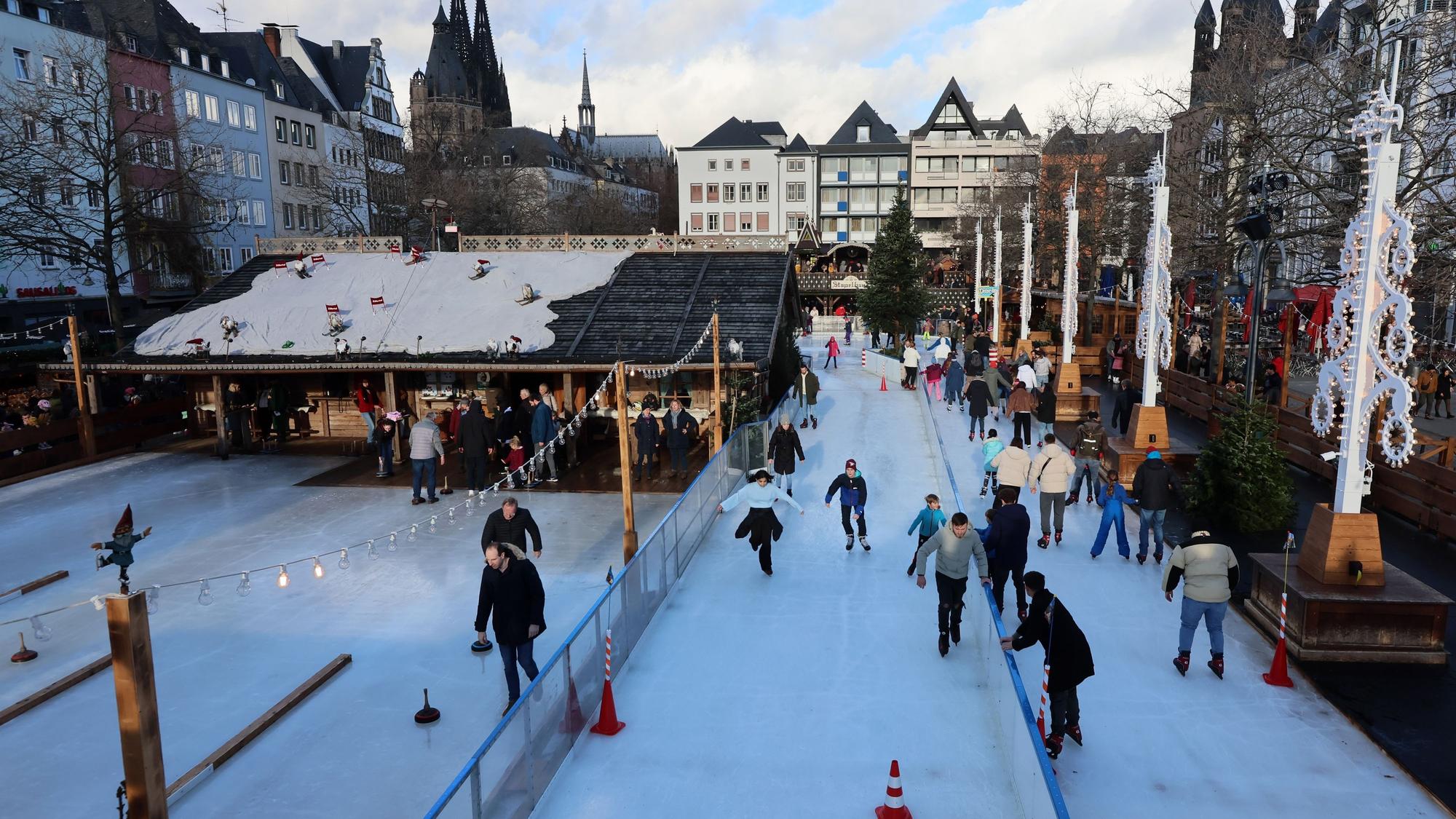 Der Weihnachtsmarkt auf dem Heumarkt mit Eisbahn und Eisstockschießen, im Hintergrund ist der Dom.