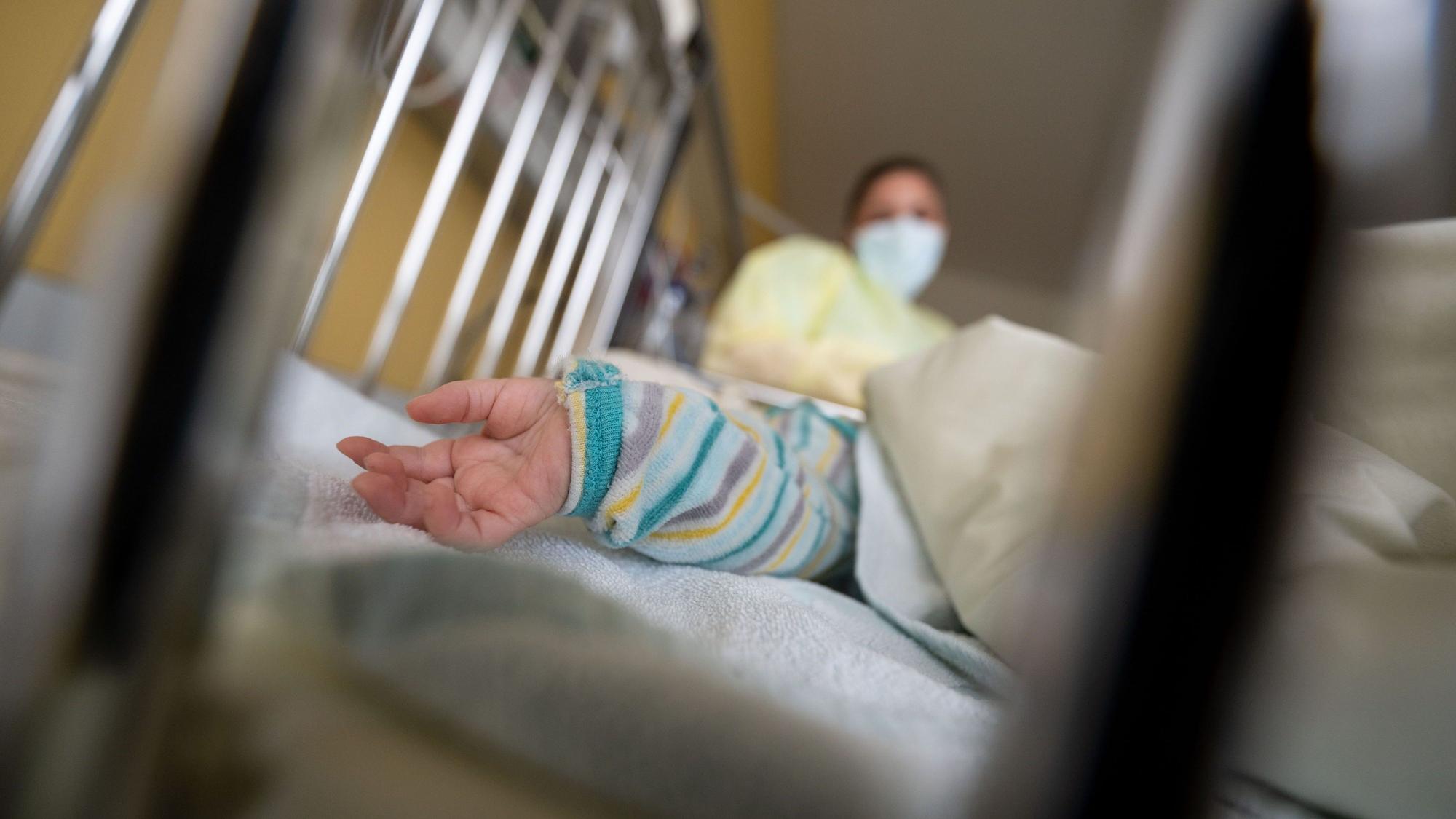 Ein erkranktes Kind liegt auf einer Kinderstation eines Klinikums in einem Krankenbett.