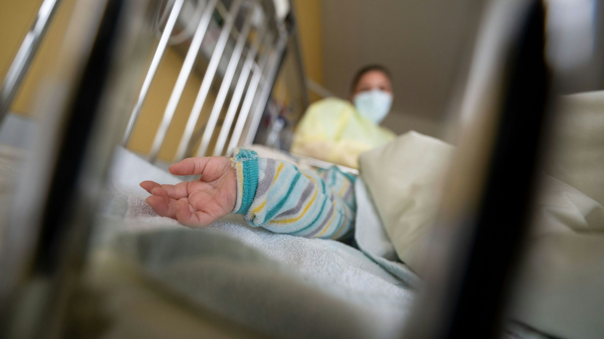 Ein erkranktes Kind liegt auf einer Kinderstation eines Klinikums in einem Krankenbett.