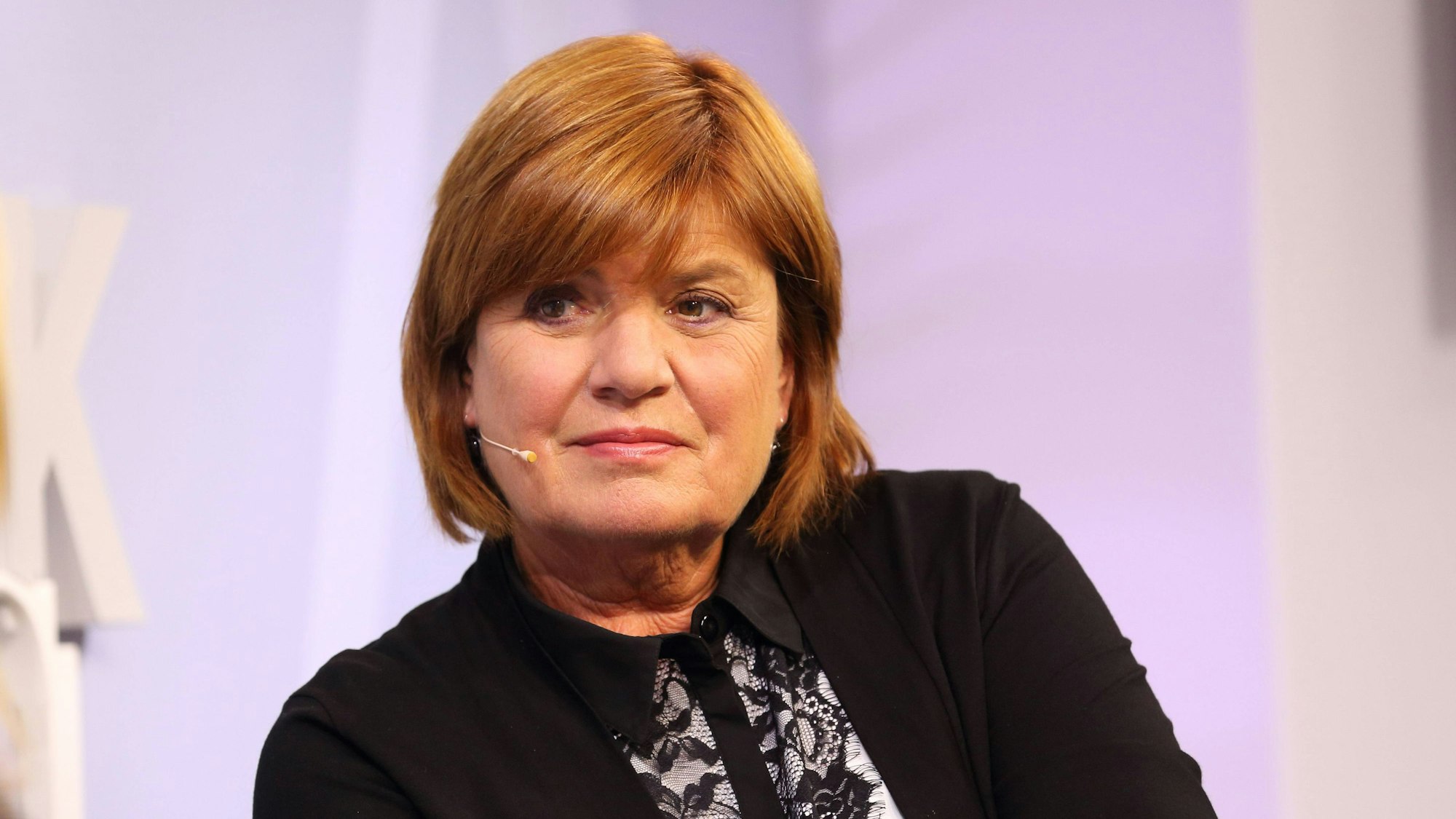 Christine Westermann ist in einer Gesprächssituation zu sehen. Sie hat ein Mini-Mikrofon auf und schaut ein unsichtbares Gegenüber aufmerksam an.