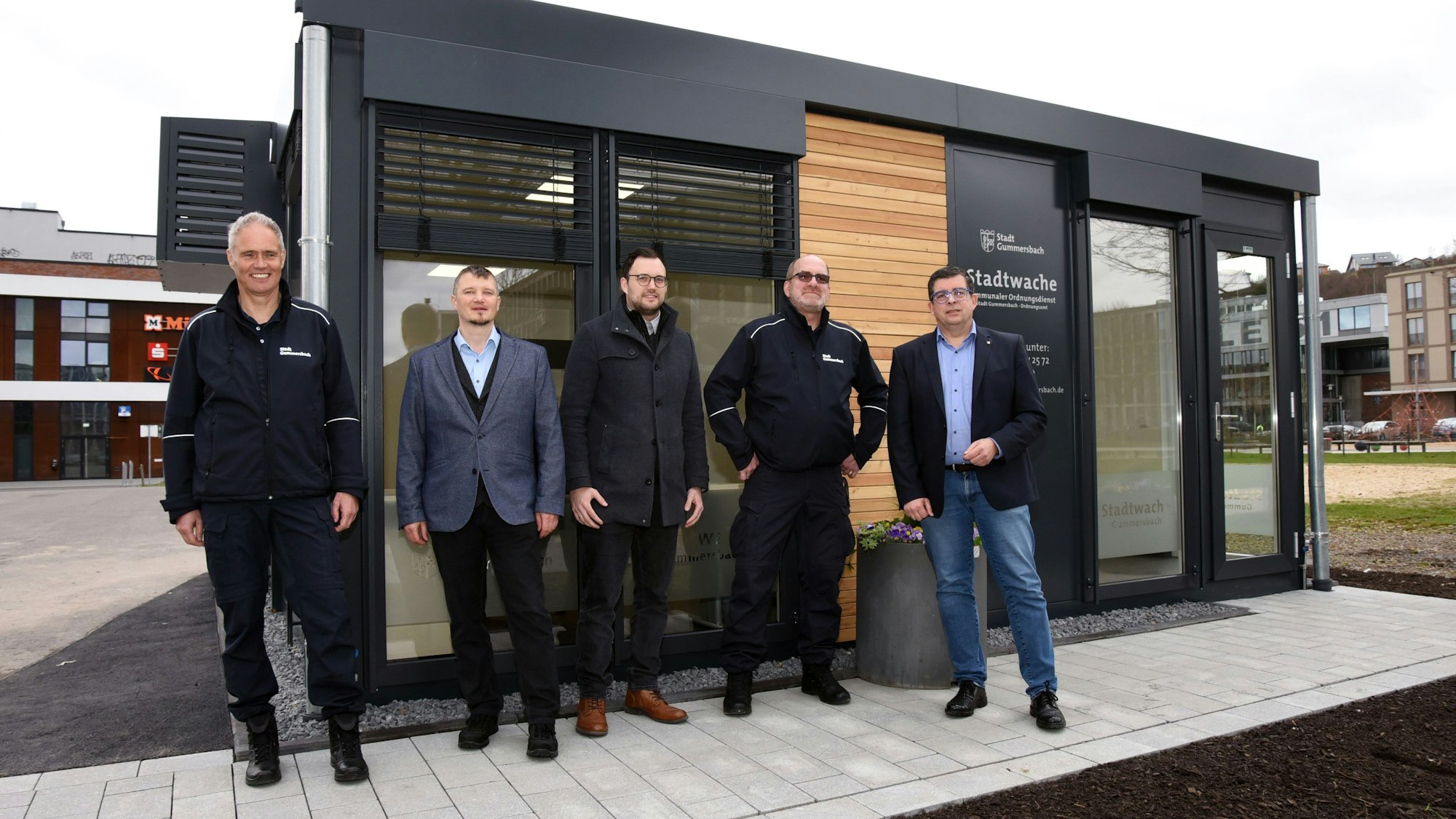 Mehrere Männer stehen vor der neuen Stadtwache auf dem Gummersbacher Steinmüllergelände.