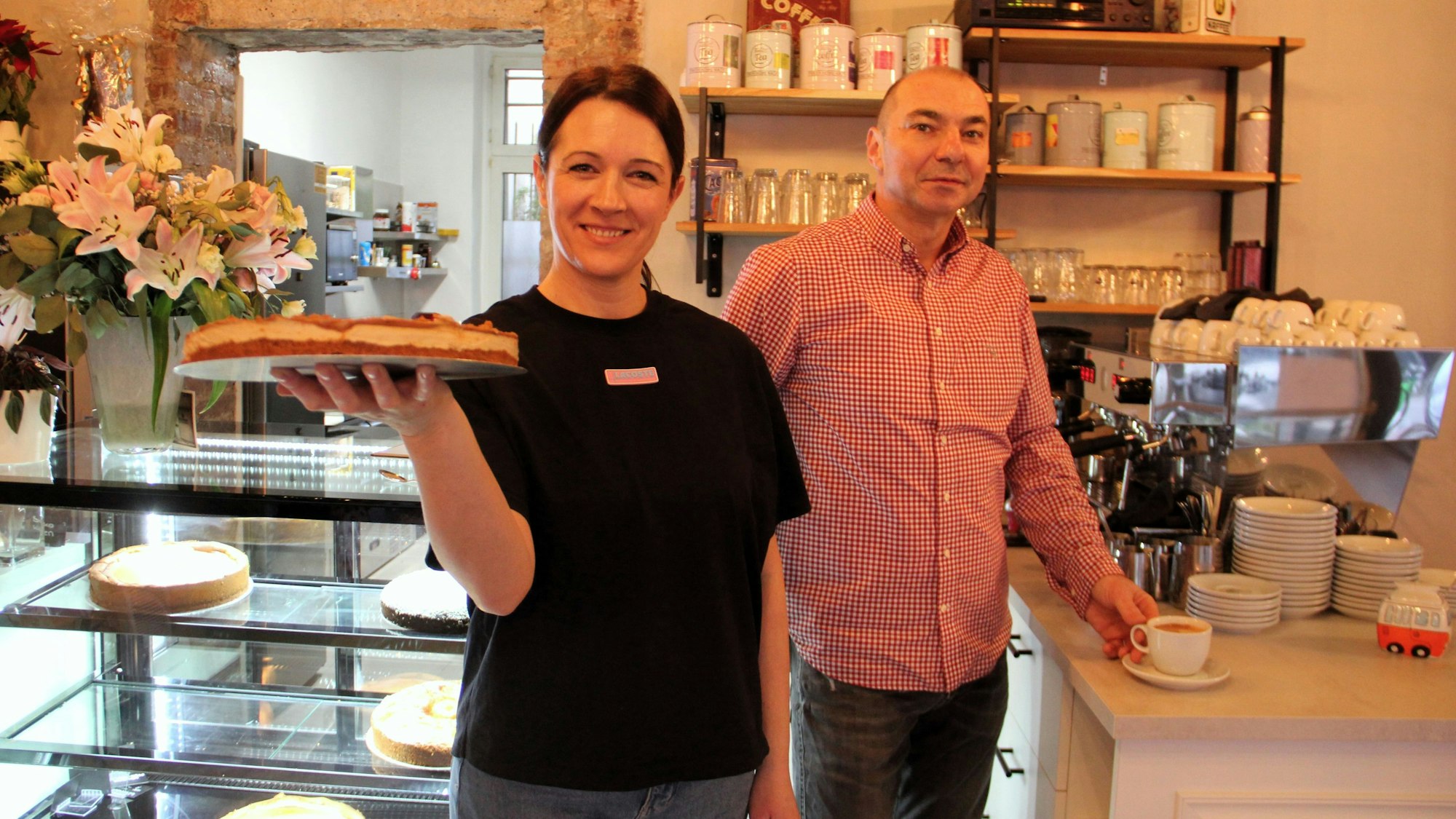 Zwei Menschen stehen mit Kuchen in der Hand am Buffet.