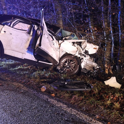 Ein total beschädigtes Auto steht vor einem Baum.