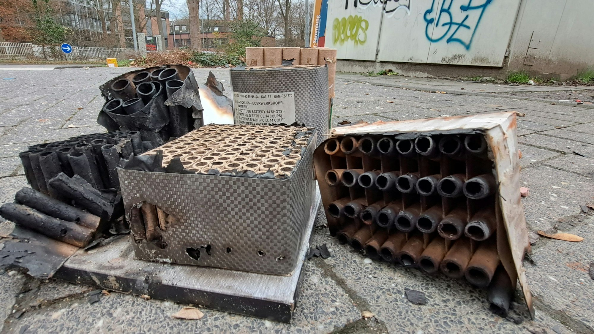 Abgebrannte Reste von Feuerwerkskörpern und Raketen liegen auf der Straße.