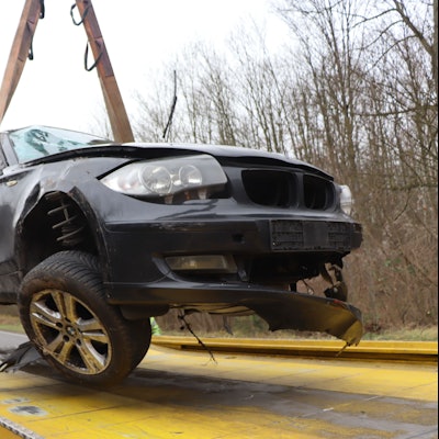 Ein bei einem Unfall schwer beschädigter BMW wird auf einen Abschleppwagen gehievt.