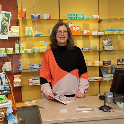 Eine Frau hinter der Verkaufstheke einer Apotheke.